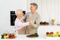 Elderly Spouses Dancing In Modern Kitchen At Home On Weekend Royalty Free Stock Photo