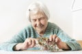 Cheerful elderly 96 years old woman sitting at table at home happy with her pension savings in her wallet after paying Royalty Free Stock Photo