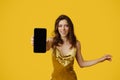 Cheerful elegant woman showing cellphone with blank screen, lady in dress recommending newest mobile app, mockup Royalty Free Stock Photo