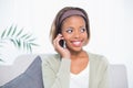 Cheerful elegant woman sitting on sofa having a phone call Royalty Free Stock Photo