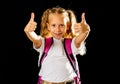 Cheerful elementary schoolgirl in uniform carrying a big backpack Royalty Free Stock Photo