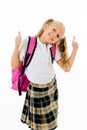 Cheerful elementary schoolgirl in uniform carrying a big backpack Royalty Free Stock Photo