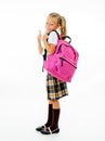 Cheerful elementary schoolgirl in uniform carrying a big backpack Royalty Free Stock Photo