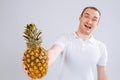 Cheerful and emotional guy holding a pineapple in his hand on a white background Royalty Free Stock Photo