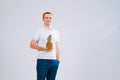 Cheerful and emotional guy holding a pineapple in his hand on a white background Royalty Free Stock Photo