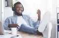 Cheerful employee relaxing at workplace, listening music and playing virtual guitar Royalty Free Stock Photo