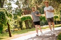 Cheerful energetic guys running in green park