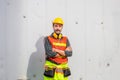 Cheerful engineer man in hard hat smiling with arms crossed and looking at camera