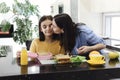 Cheerful ethnic mother making healthy lunch box with healthy food for her little daughter