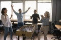 Cheerful euphoric colleagues playing table soccer at lunch break Royalty Free Stock Photo