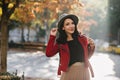 Cheerful european girl with short black hair posing in sunny september day. Outdoor portrait of wonderful lady in jacket