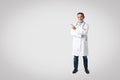 Cheerful european senior man doctor in white coat with stethoscope points finger at empty space