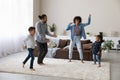 Cheerful excited active African family dancing to music, going wild Royalty Free Stock Photo