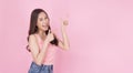 Cheerful excited asian woman use finger pointing to side with product or empty copy space standing over isolated pink background. Royalty Free Stock Photo