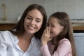 Cheerful excited little girl sharing secret with happy mom Royalty Free Stock Photo