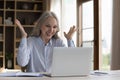 Cheerful excited mature business freelance woman receiving great good news