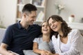 Cheerful excited parents and kid having fun together on couch