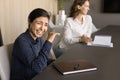 Cheerful excited pretty Indian employee laughing at corporate meeting