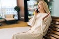 Cheerful excited young blonde woman talking on mobile phone, smiling discussing some latest news, enjoying nice Royalty Free Stock Photo