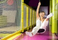 Cheerful girl swinging on indoor zip line at play center Royalty Free Stock Photo