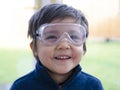 Cheerful exited little boy wearing protective glasses looking at camera with smiling face, Cute kid wearing safety glasses. Protec