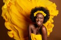 Cheerful Expression Afro American Model over Yellow Silk Flying Fabric Background. Happy Smiling Young Dark Skinned Woman Singing Royalty Free Stock Photo