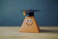 A cheerful expression with a graduation cap placed on a wooden block, symbolizing education and decision-making Royalty Free Stock Photo