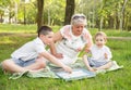 Cheerful extended family playing board game in their backyard.