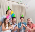 Cheerful extended family playing with Christmas crackers