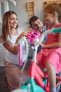 Cheerful family buying new bicycle and helmet for happy girl in bike shop Royalty Free Stock Photo