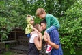 Cheerful family of four having fun at countryside. The father kisses mother. Royalty Free Stock Photo