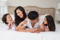 Cheerful family of four lying in bed Royalty Free Stock Photo