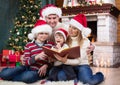 Cheerful family of four reading together on Royalty Free Stock Photo