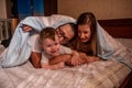 Cheerful family hiding with baby son under blanket. Mother and father try to catch an active baby Royalty Free Stock Photo