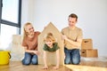 Cheerful family and kid boy playing in new home with cardboard boxes on floor. Portrait Royalty Free Stock Photo