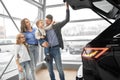 Cheerful family looking at big capacious trunk of new car Royalty Free Stock Photo