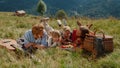 Cheerful family lying grass enjoying picnic on meadow. Summer holiday together. Royalty Free Stock Photo