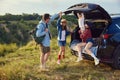 Cheerful family, man and woman spending time with children outdoors, going hiking, doing picnic on hill. Beautiful Royalty Free Stock Photo