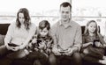 Cheerful family members spending time playing with smartphones Royalty Free Stock Photo