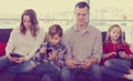 Cheerful family members spending time playing with smartphones Royalty Free Stock Photo