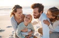 Cheerful family playing on the beach. Parents bonding with their children on the beach. Happy children playing with Royalty Free Stock Photo