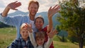 Cheerful family posing camera on green mountains. Parents have fun with kids. Royalty Free Stock Photo