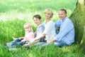 Cheerful family resting under tree Royalty Free Stock Photo