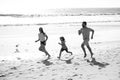 Cheerful family running on the beach. Happy mother father with child son, having fun during summer holiday. Active Royalty Free Stock Photo