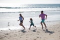 Cheerful family running on the beach. Happy mother father with child son, having fun during summer holiday. Active Royalty Free Stock Photo