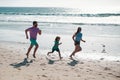 Cheerful family running on the beach. Happy mother father with child son, having fun during summer holiday. Active Royalty Free Stock Photo