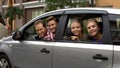 Cheerful family sitting in car and smiling into camera, auto rental, insurance