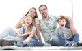 Cheerful family sitting on the carpet in the new living room Royalty Free Stock Photo