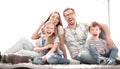 Cheerful family sitting on the carpet in the new living room Royalty Free Stock Photo