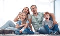 Cheerful family sitting on the carpet in the new living room Royalty Free Stock Photo